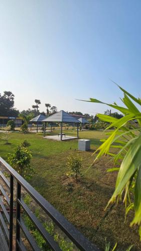 a park with a gazebo and a fence at Balaji Hotel and Resturant in Kolaghat