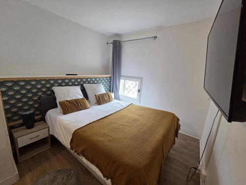 a bedroom with a bed and a flat screen tv at Résidence Austerlitz centre Angouleme in Angoulême