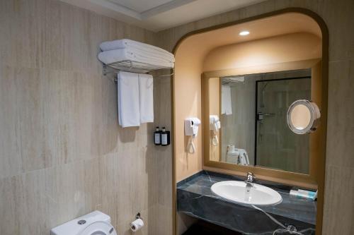 a bathroom with a sink and a mirror at Sheraton Khalidiya Hotel in Abu Dhabi