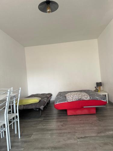 a room with two beds and a table and chairs at Logement type studio 1 piece proche zénith in Strasbourg