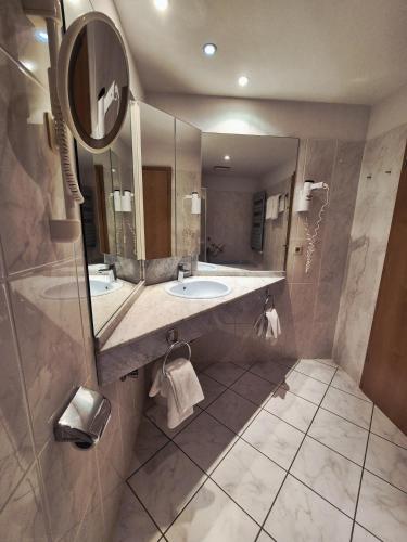 a bathroom with a sink and a mirror at Hotel Hahnenkleer Hof in Hahnenklee-Bockswiese