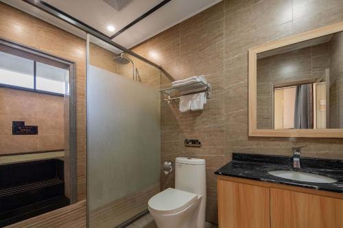 a bathroom with a toilet and a sink and a mirror at ZSZ Hot Spring Resort in Shajing