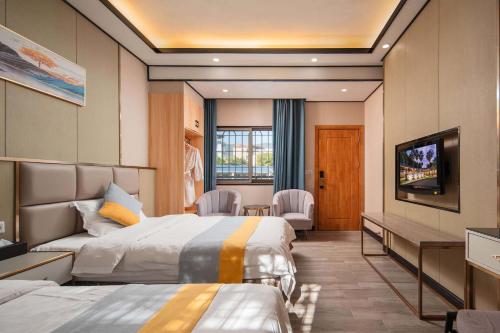 a hotel room with two beds and a flat screen tv at ZSZ Hot Spring Resort in Shajing