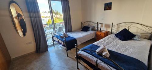 una camera da letto con due letti e un balcone di Peyia Sunset a Peyia