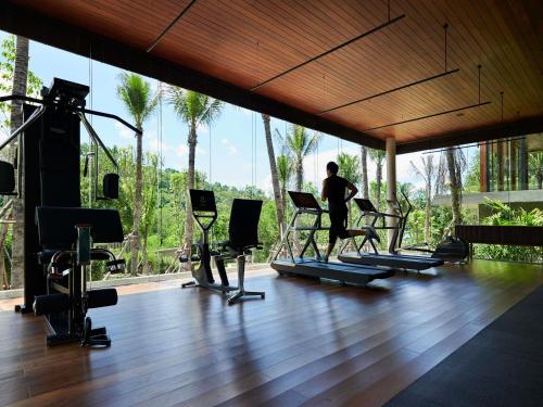 a man running on a treadmill in a gym at V Villas Phuket - MGallery Collection in Panwa Beach