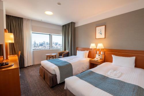 a hotel room with two beds and a window at Toshi Center Hotel in Tokyo