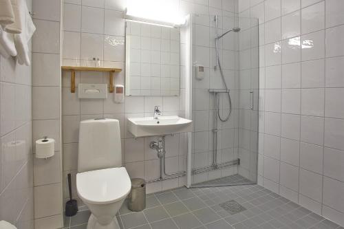 a bathroom with a toilet and a sink and a shower at Hotell Högland in Nässjö