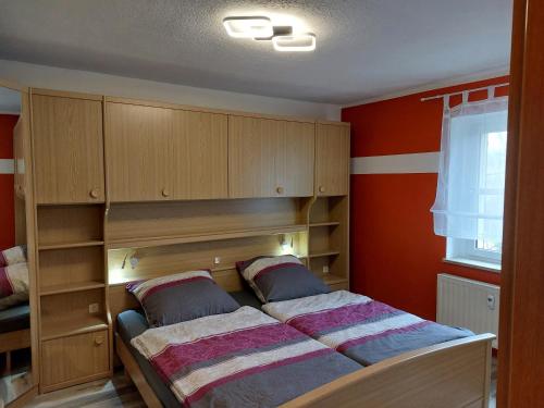 a bedroom with a bed with wooden cabinets and a window at Apartment Erzgebirgsperle in Schwarzenberg