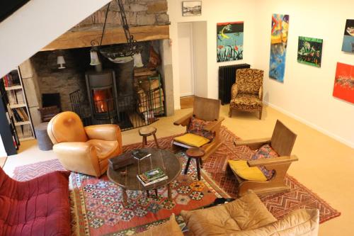 un salon meublé avec une cheminée dans l'établissement Le Chai, à La Celle-sous-Gouzon