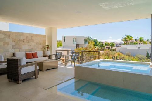 a patio with a swimming pool and a living room at Villa Real para 12 personas con piscina privada in Cabo San Lucas
