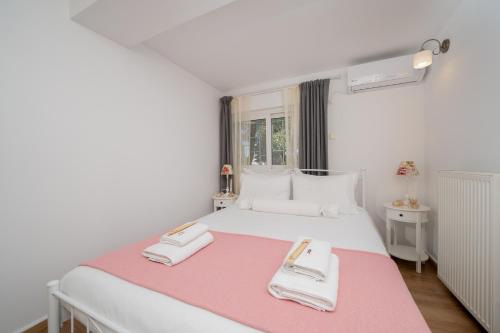 a bedroom with a white bed with two towels on it at Livingstone House in Porto Rafti