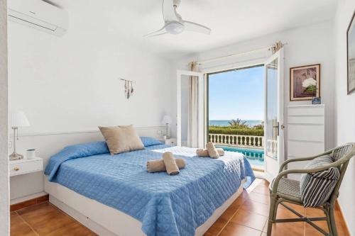 a bedroom with a bed with a view of the ocean at Villa Caprice by Villa Plus in S'Algar