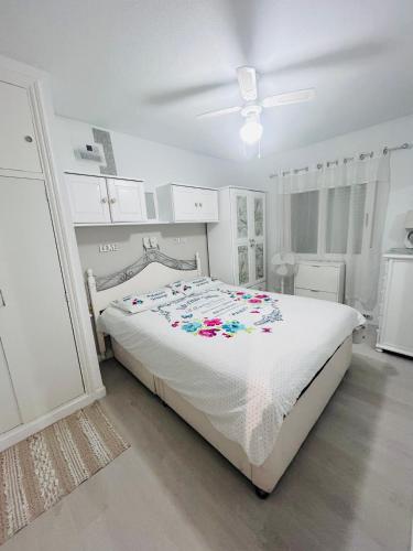 a white bedroom with a bed and a ceiling fan at Laguna 88 in La Mata
