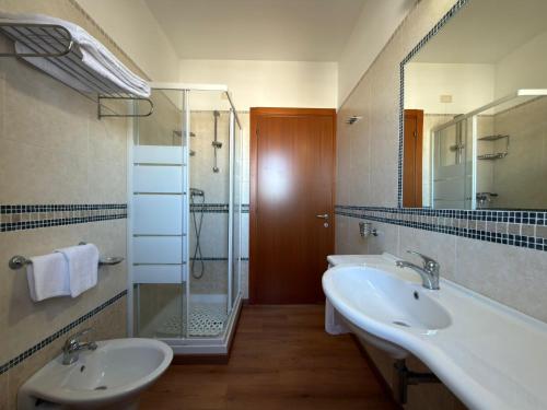 a bathroom with two sinks and a glass shower at Residence il Girasole 1 in Alba Adriatica