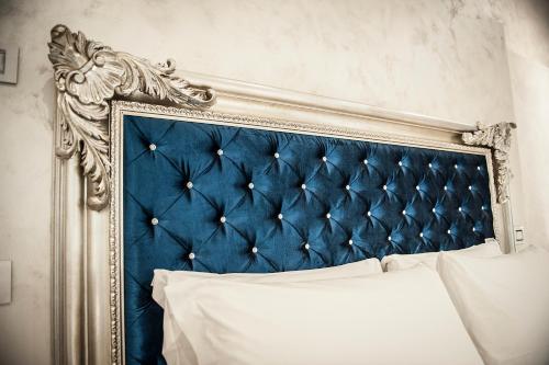 1 cama con cabecero azul en un dormitorio en Arena Easy Suites Guesthouse, en Verona