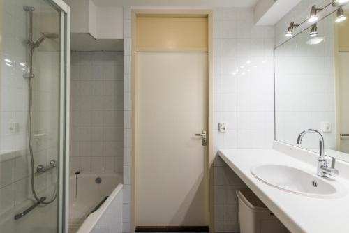 a white bathroom with a sink and a shower at Vleijenhof Type B in Buren