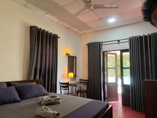 a bedroom with a bed and a table with chairs at Bella Sunset Point in Embilipitiya