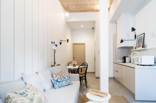 a living room with a white couch and a table at Apartamentos Territorios in Mérida