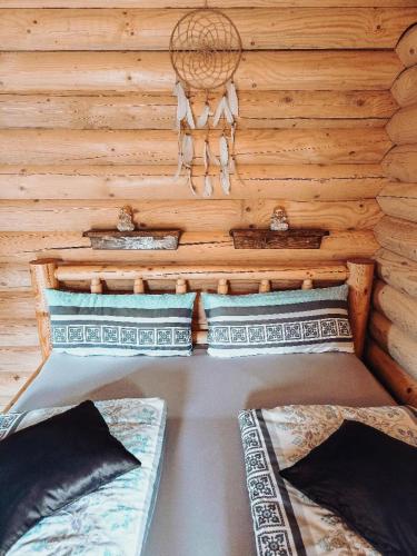 two beds in a room with a wooden wall at Chalet Hüttendorf 49 gradnord in Bayerisch Eisenstein
