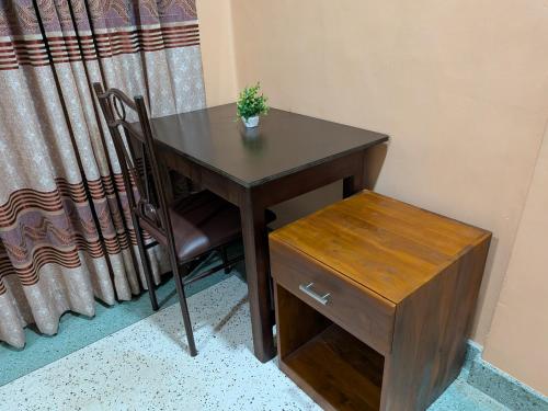 a wooden table with a chair and a wooden drawer at Seethevi Hotels in Batticaloa