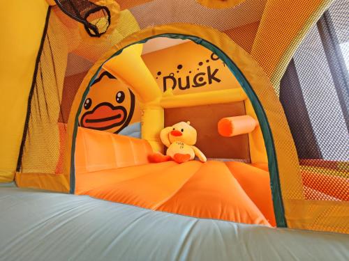 a teddy bear sitting on a bed in an inflatable tent at Naughty Castle Playground & Ball Pool in Johor Bahru