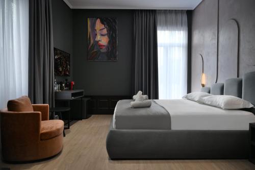 a bedroom with a large bed and a chair at Hotel Bel Ami Tirana in Tirana