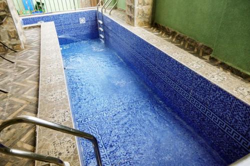 a blue bath tub with blue tiles in a bathroom at Dawn Emeka Hotels in Akwa