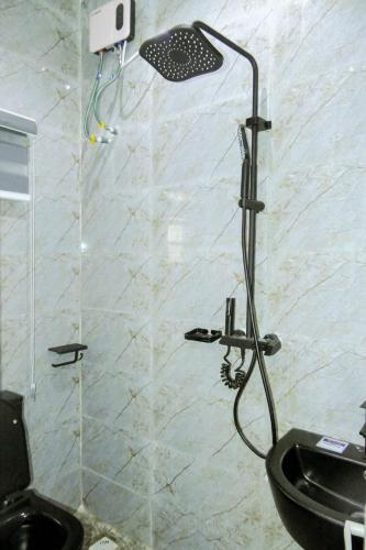 a shower in a bathroom with a toilet and a sink at Dawn Emeka Hotels in Akwa