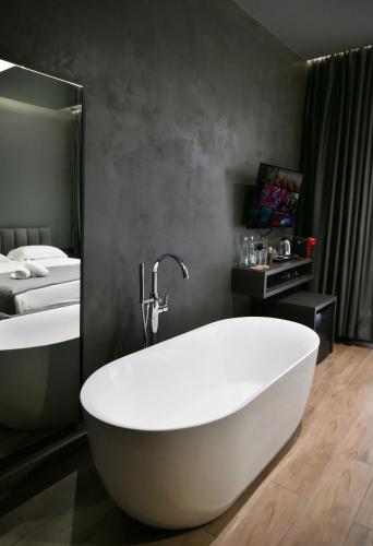 a bathroom with a white tub and a sink at Hotel Bel Ami Tirana in Tirana
