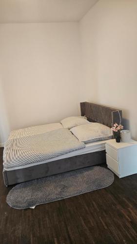 a bed in a bedroom with a white wall at Die Schöne Wohnung am Stade Bahnof in Stade