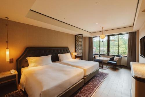ein Hotelzimmer mit einem großen Bett und einem Schreibtisch in der Unterkunft Mampei Hotel in Karuizawa