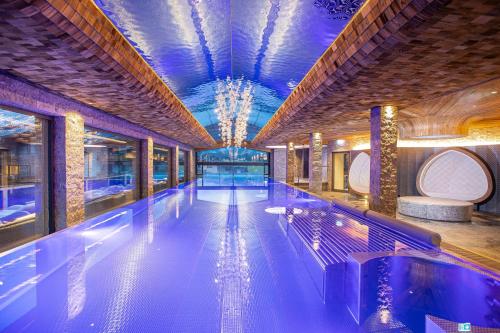 a swimming pool in a building with a blue ceiling at Chalets Grossmitt in Pertisau
