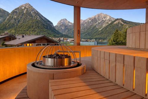 a fire pit on a deck with mountains in the background at Chalets Grossmitt in Pertisau