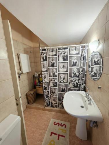 a bathroom with a sink and a shower at Mairi’s Apartment in Nea Artaki