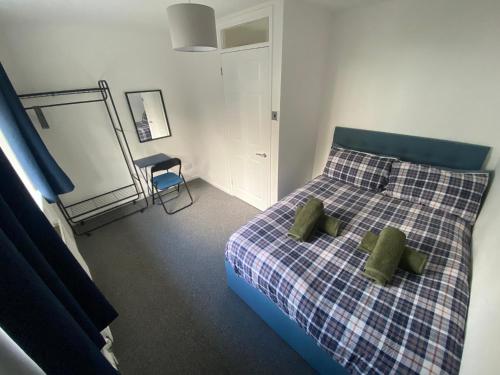 a bedroom with a bed with two green pillows at Home in Cwmbran with free onsite parking in Cwm-brân