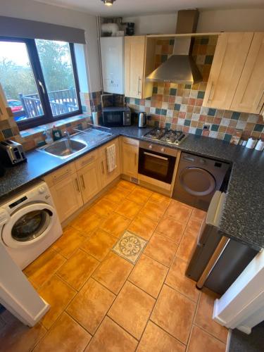 a kitchen with a washer and a sink and a stove at Home in Cwmbran with free onsite parking in Cwm-brân