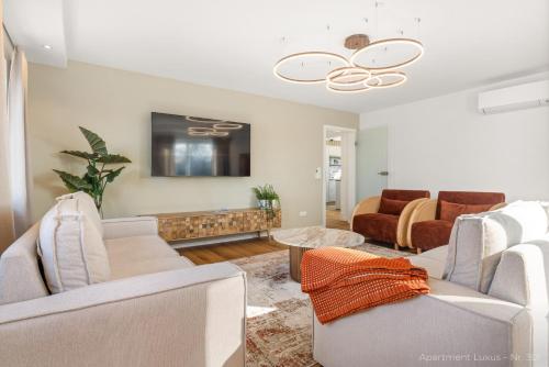 a living room with white furniture and a tv at Bad Aibling Apartments in Bad Aibling