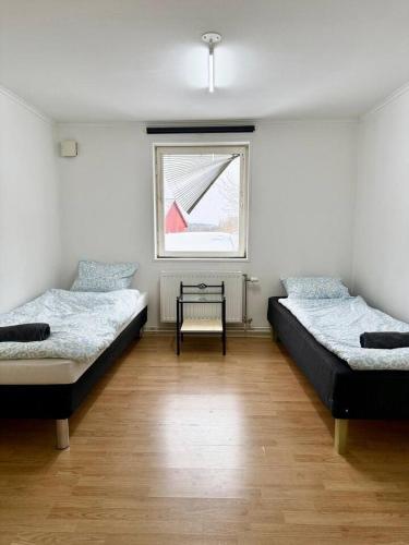 two beds in a room with a window at Workers Stay - Staff Accommodation Säve - Göteborg in Säve