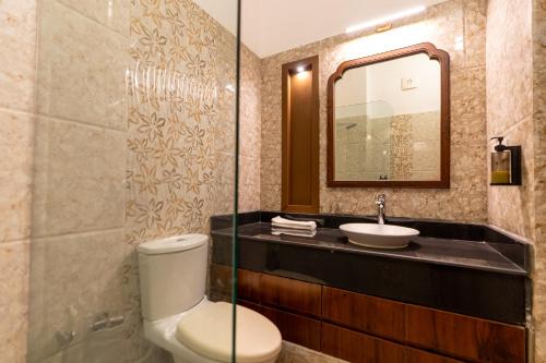 a bathroom with a toilet and a sink at Aranyam in Rishīkesh