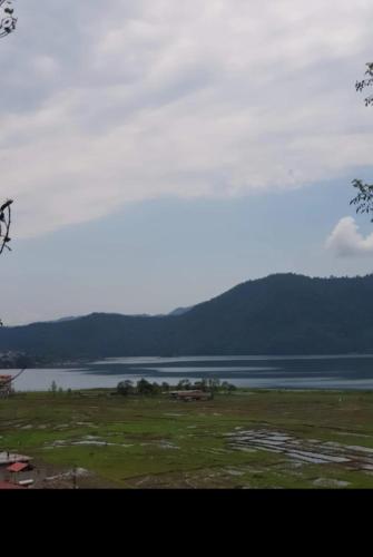 una vista di un lago con le montagne sullo sfondo di Nirvana Guest House a Pokhara