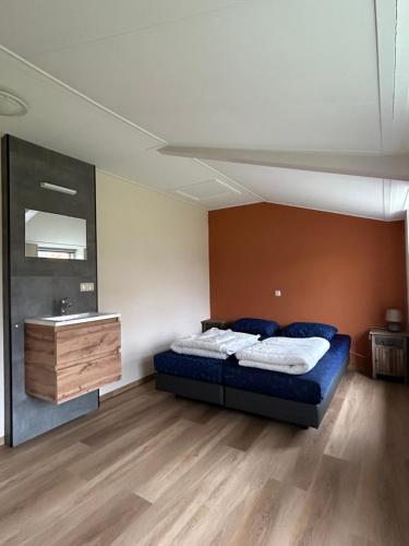 a bedroom with a bed and a sink in it at T Skûttegat in Hollum