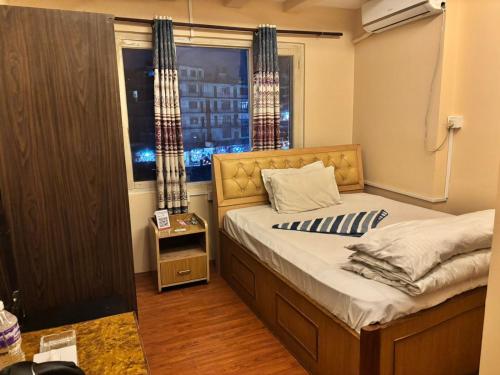 a bedroom with a bed and a window with a city at Hotel Syangbo Brothers in Kathmandu