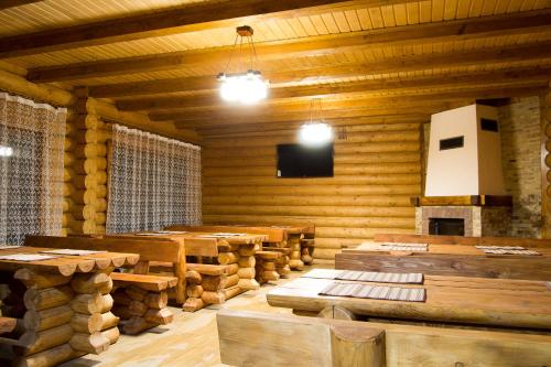 a large room with wooden tables and a fireplace at Sadyba Pikuy in Bilasovytsya