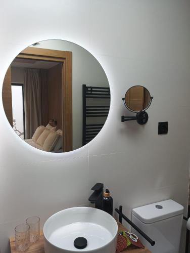 a bathroom with a white sink and a mirror at Apartamento rural Rubí in El Torno
