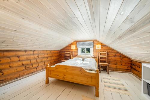 a bedroom with a bed in a log cabin at Det Hvite Hus - Fosseland Hytter in Feda