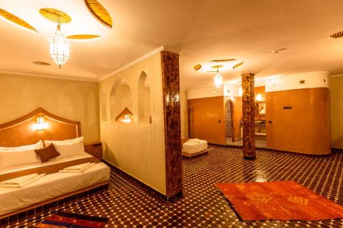 a hotel room with two beds and a bathroom at Hotel Sunset Palace Merzouga in Merzouga