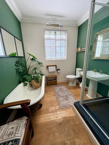a bathroom with a tub and a toilet and a sink at Oatlands Cottages in Grahamstown