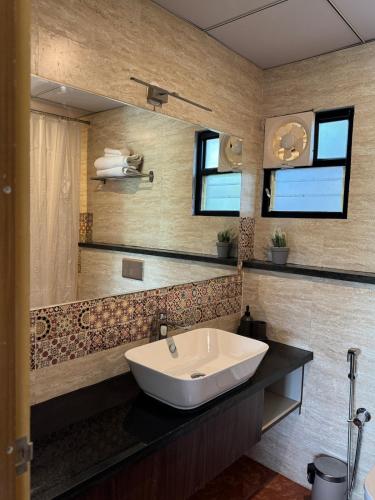 a bathroom with a sink and a mirror at Bhoomi in Mysore