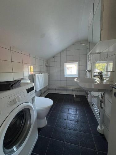 a bathroom with a washing machine and a sink at Workers Stay - Worker Accommodation Torslanda - Volvo - Sweden in Gothenburg