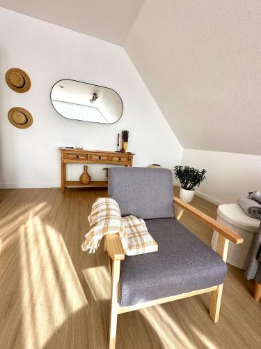 a living room with a chair and a table at Casa del Sol - Ferienwohnung Norddeich in Norddeich